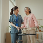 Aid assisting woman with a walker