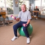 Pete lifting weights on an exercise ball